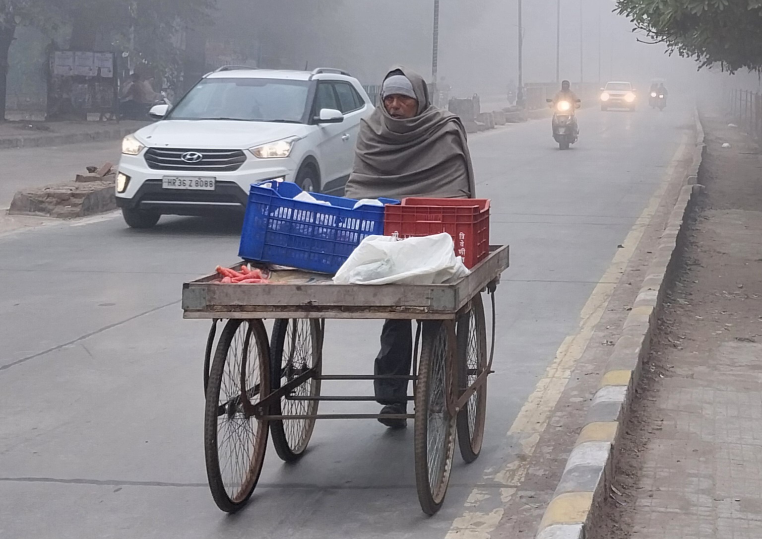 रेवाड़ी। रविवार सुबह रेहड़ लेकर ठंड में बचाव करता जाता बुजुर्ग।